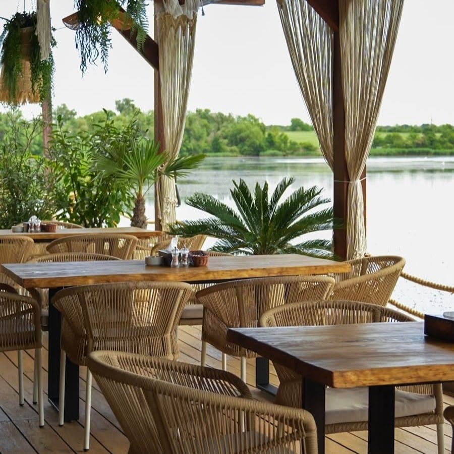 Terasa cu mobilier de lemn, pergola si perdele de in de la restaurant Garuda, Cernica