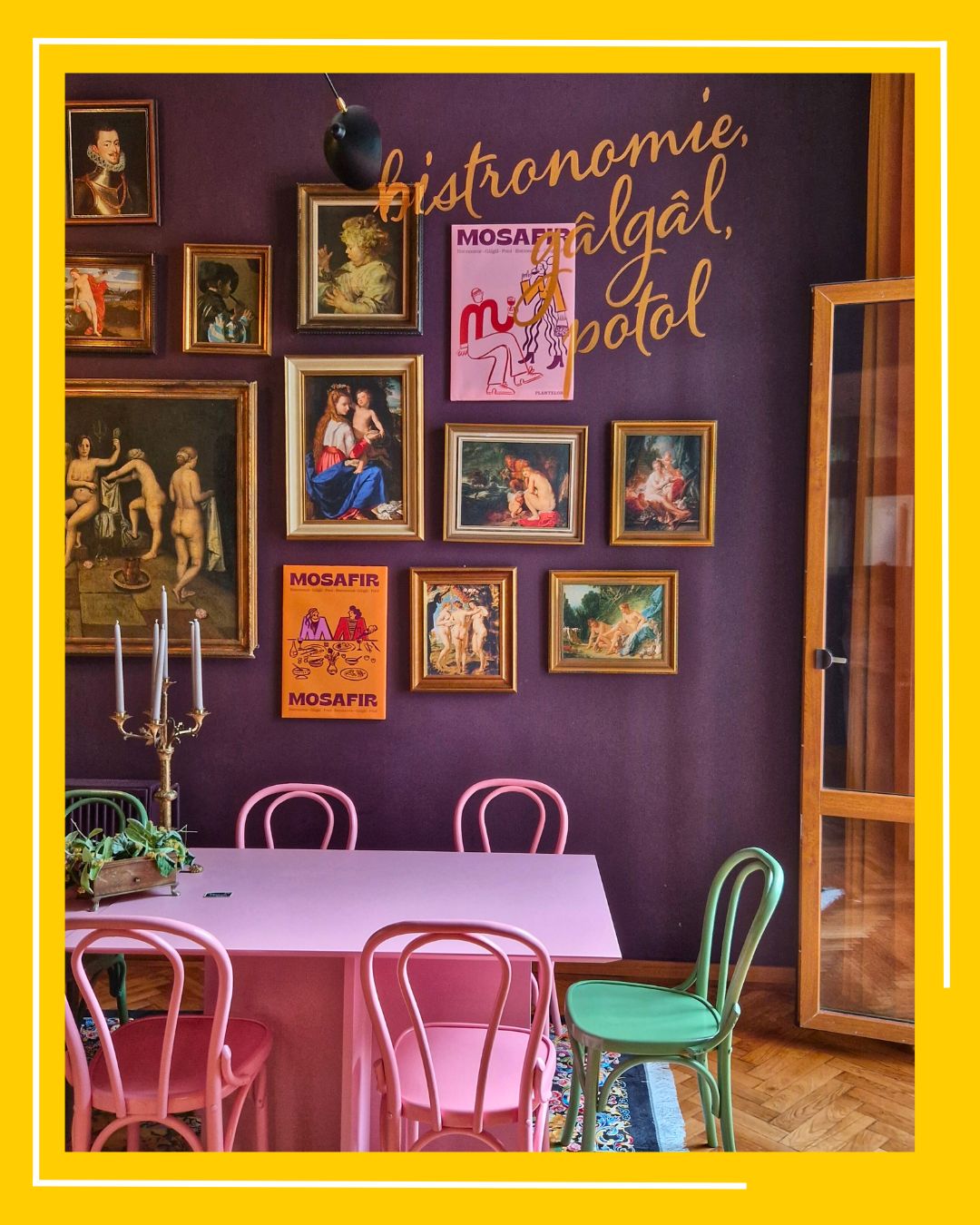 imagine din interiorul restaurantului Mosafir, cu un perete mov plin de tablouri, o masa si scaune rox