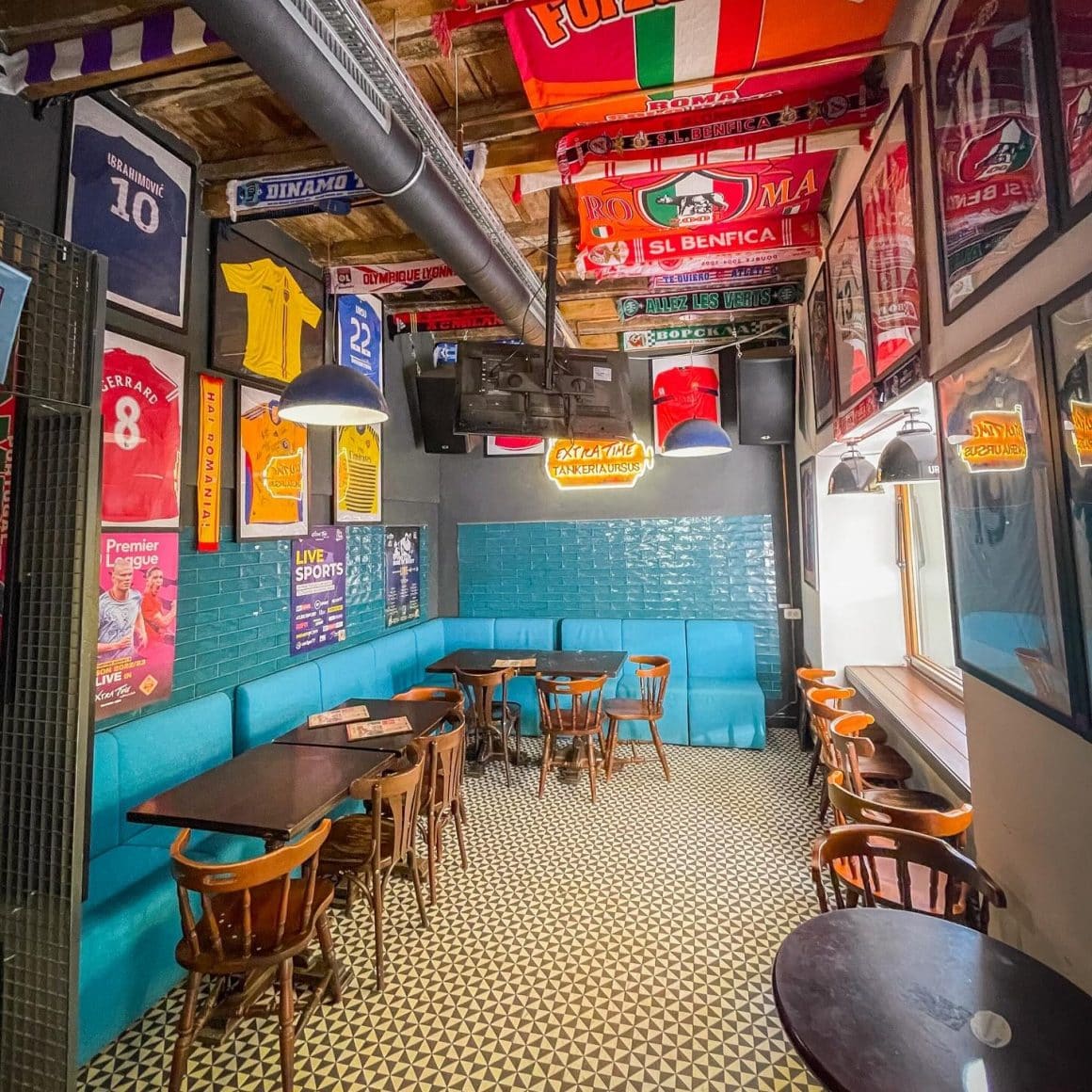 interiorul publui Extra Time din București, decorat colorat, cu multe tablouri cu tricouri sportive pe pereti. Terase și baruri sportive București