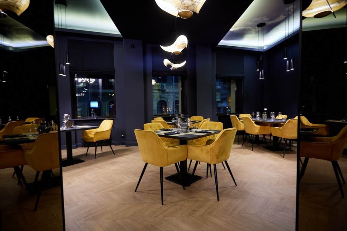 imagine din restaurant Boem, amenajat elegant, in culori inchise si pereti negri, cu mobilier din catifea galbena. Locuri noi București