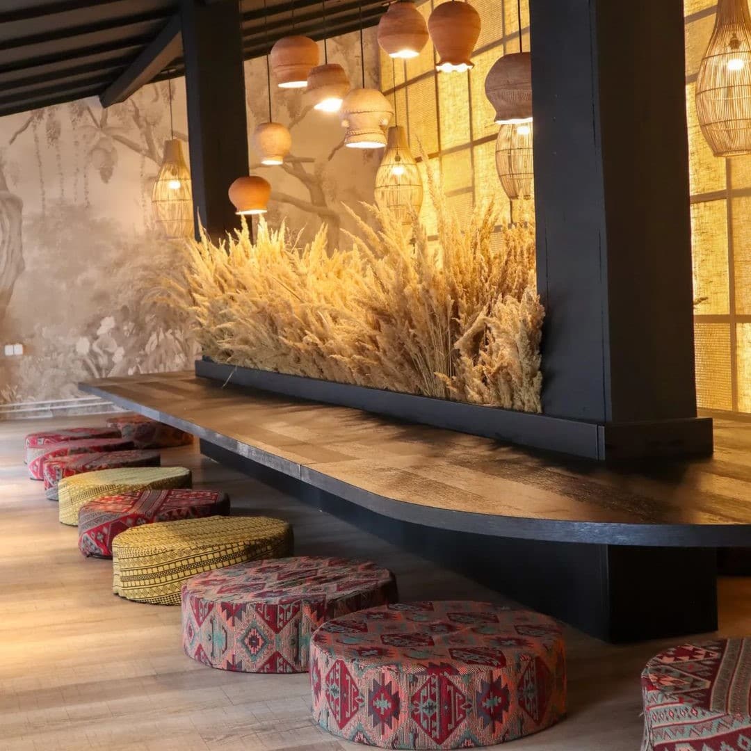 imagine din interiorul restaurantului Momo, cu o masa lunga, centrala, si tabureti de-a lungul ei