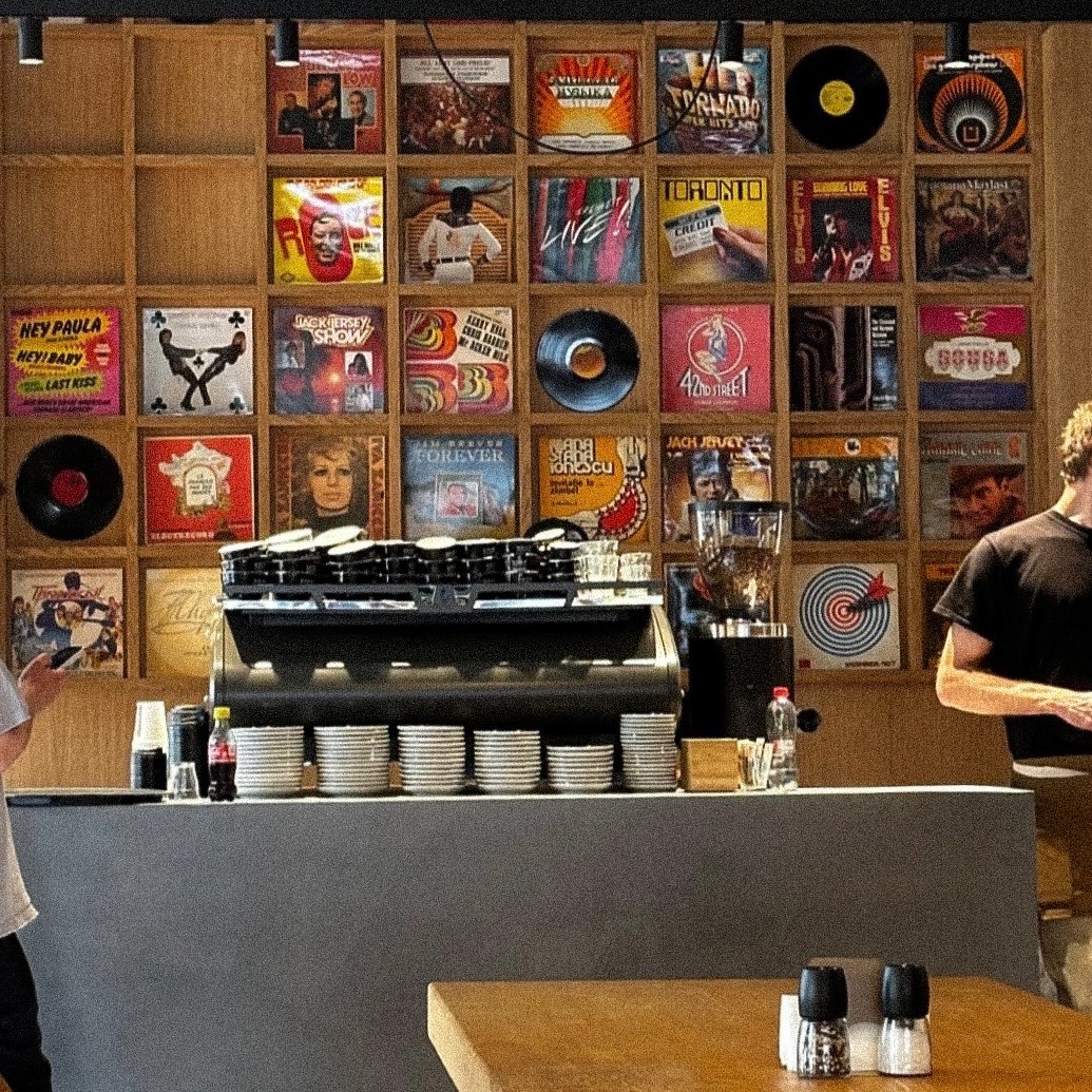 Coffee bar, perete cu vinyluri și atmosferă relaxată în spațiul Frudisiac Brod din București.