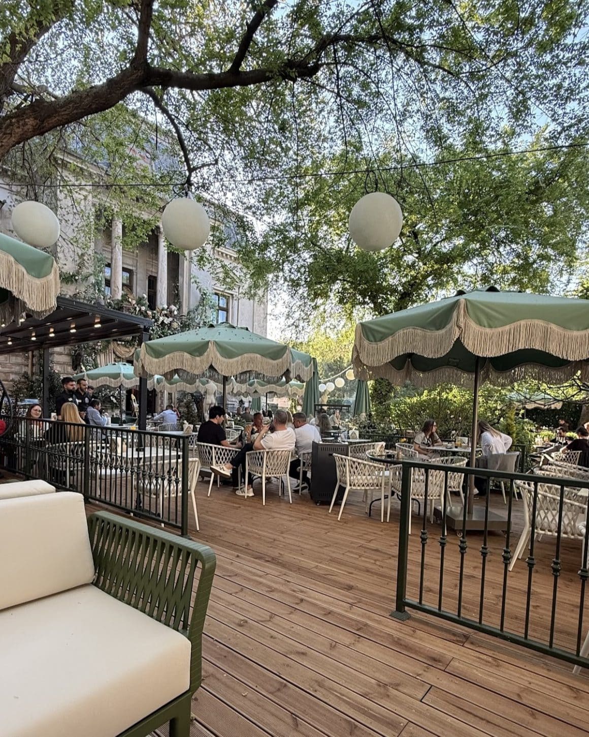 Terasă elegantă cu umbrele verzi, grădină urbană și atmosferă rafinată la Grand Café de Bucarest. Locuri noi în București