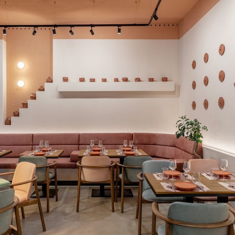 interiorul restaurantului Mezeya, decorat in nuante de caramiziu, crem, verde menta si roz, cu canapea de colt si mese de 4 persoane