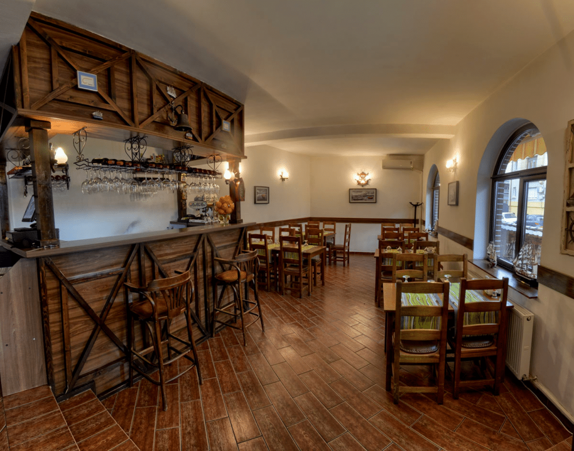 interiorul restaurantului La Zavat, amenajat in stil rustic, ca o taverna, cu mese si scaune din lemn. Cele mai bune restaurante grecești din București