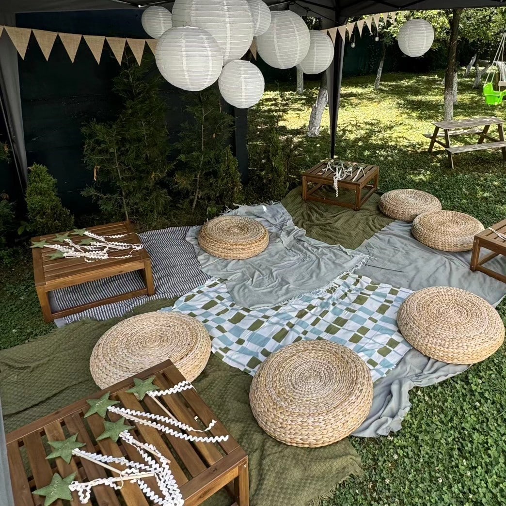 zona de relaxare amenajata cu poufuri otoman, paturi si lumini decorative, pe iarba in curte la Zaivan Retreat