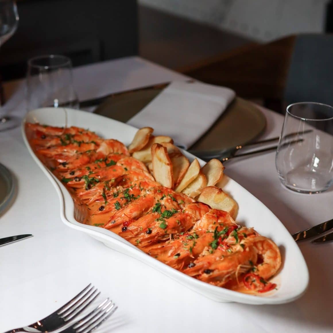 „Buzara” cu creveți – un dish de inspirație croată, cu ghimbir, lemon grass, lime, usturoi, vin și smântână. de la Fish House. Restaurante cu fructe de mare București