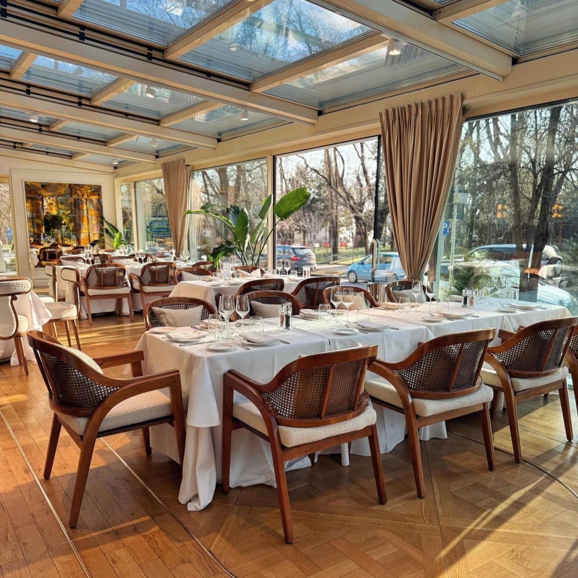 Terasă Akos Restaurant cu pereți de sticlă și vedere spre parc, una dintre cele mai moderne terase din Herăstrău.