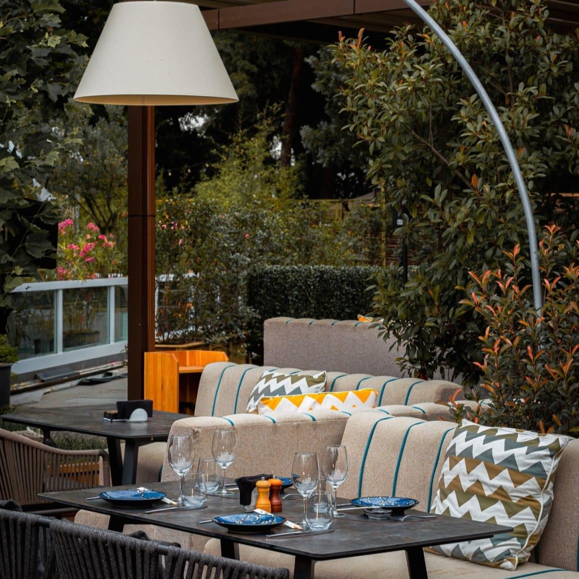 Colț cozy pe terasa Argentine Herăstrău, cu canapele confortabile, perne decorative și atmosferă relaxată.