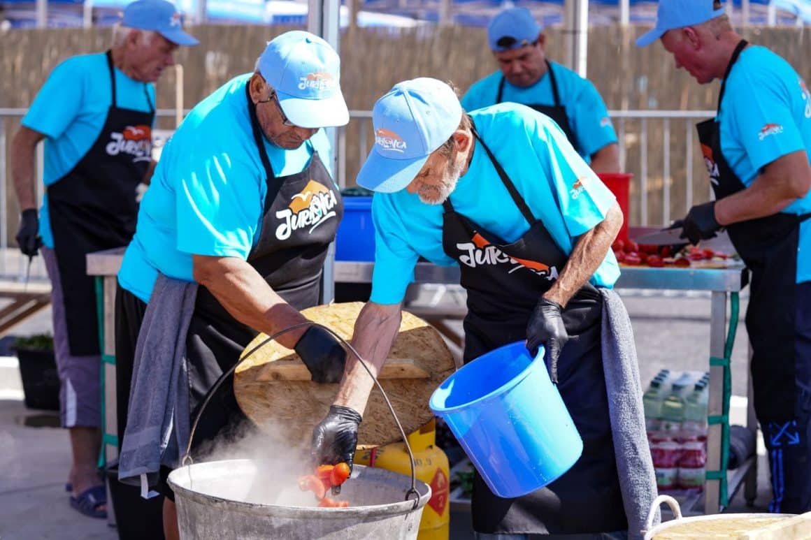 barbati in șorț de bucatar si tricouri albastre pregatesc un ceaun cu borș lipovenesc. Târguri gastroniomice de toamnă: Festivalul Borșului Lipovenesc