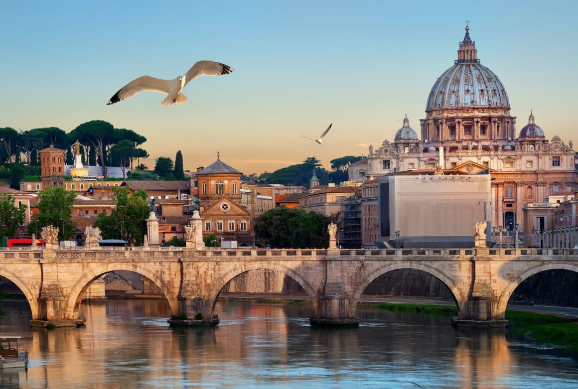 Panorama asupra orașului Roma, fotografiat toamna, cu privire catre un pod ce traverseaza raul si cladirea Vaticanului. Cele mai frumoase destinații de toamnă, capitale europene pentru city break. Ce să vizitezi și unde să mănânci.