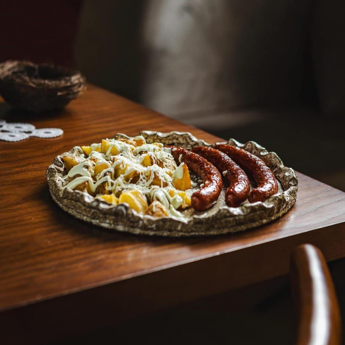 Cârnați de capră cu cartofi prăjiți în stilul nostru, brânză rasă și maioneză de lapte de la restaurant Străbun