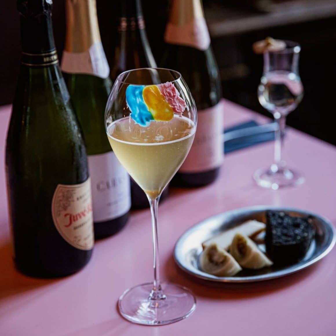 pahar de vin alb cu steagul romaniei desenat pe el, iar in fundal sticle de vin de la Mosafir. unde sa mergi de 1 decembrie la restaurant