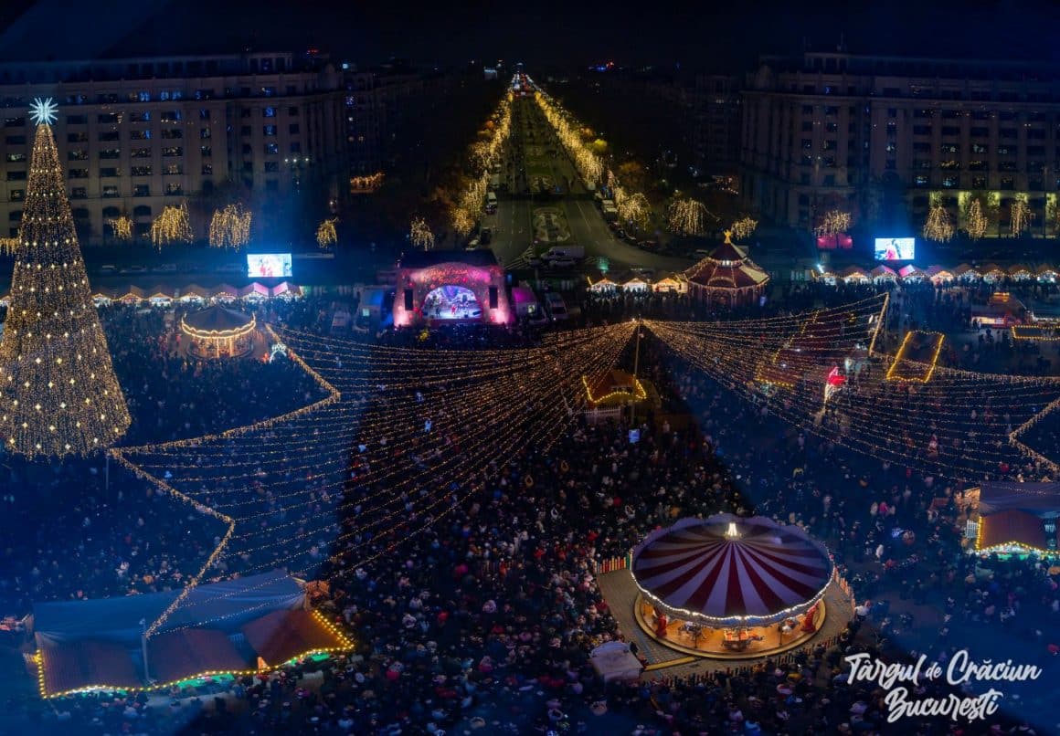 imagine de ansamblu, fotografiata de sus, noaptea, la Targul de Crăciun din Piața Constituției, București, cu brad impodobit, carusel si luminite aprinse. Târguri de Crăciun București 2024