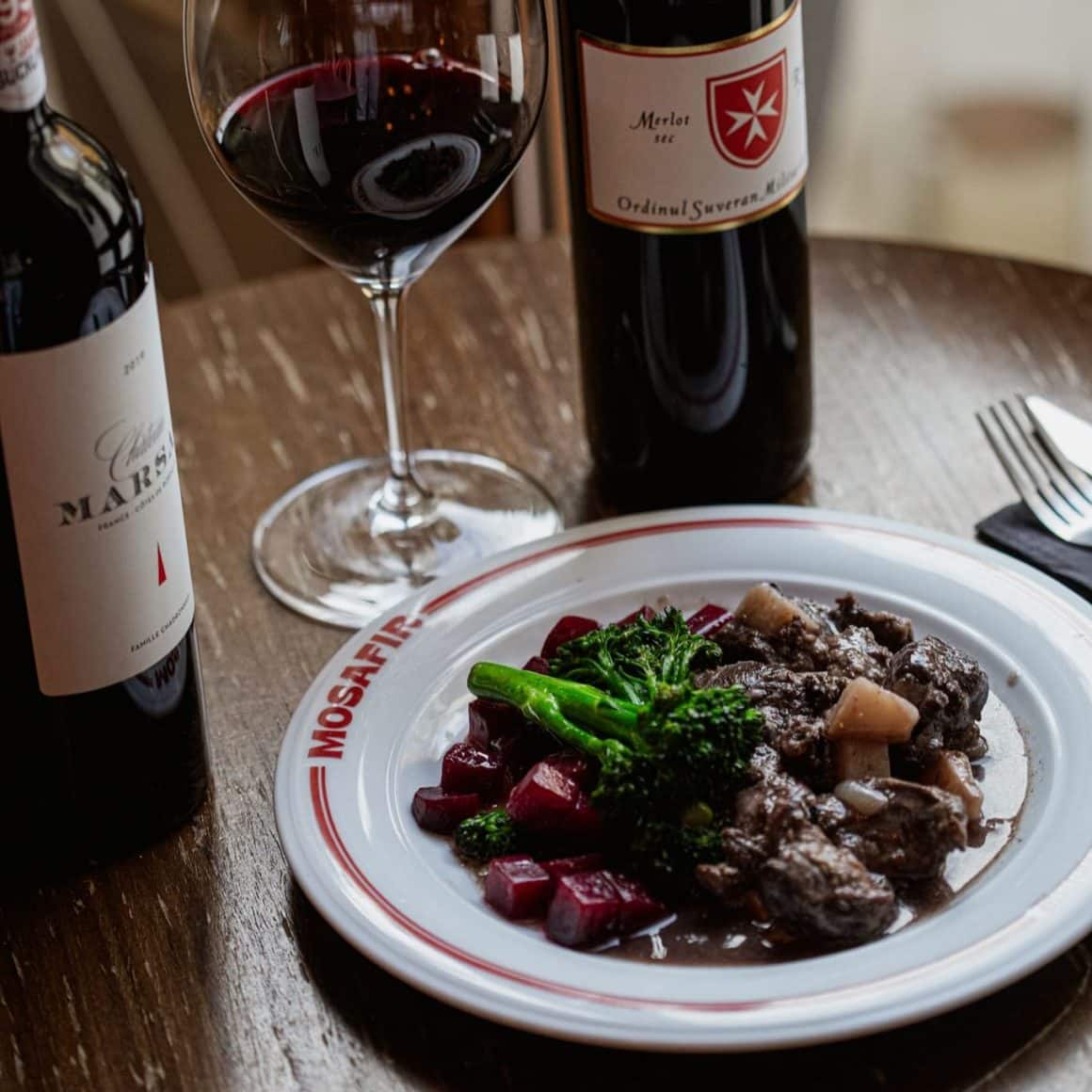 Obrajori de miel Mosafir 
Obrajorii de miel de la Ferma Berke sunt gătiți lent, în vin roșu și legume, până ating frăgezimea perfectă. Carnea, provenită dintr-o fermă locală din Covasna, unde animalele sunt crescute liber și hrănite natural, are o textură fină și un gust curat, echilibrat.