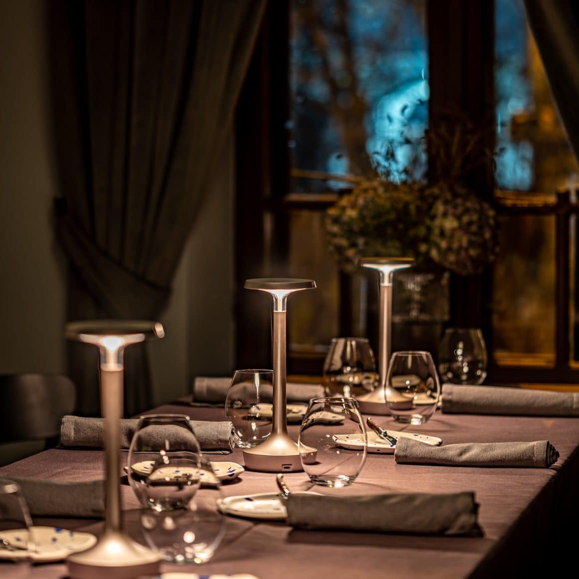 close up cu o masa eleganta, cu lumini difuze de la lumna lampilor