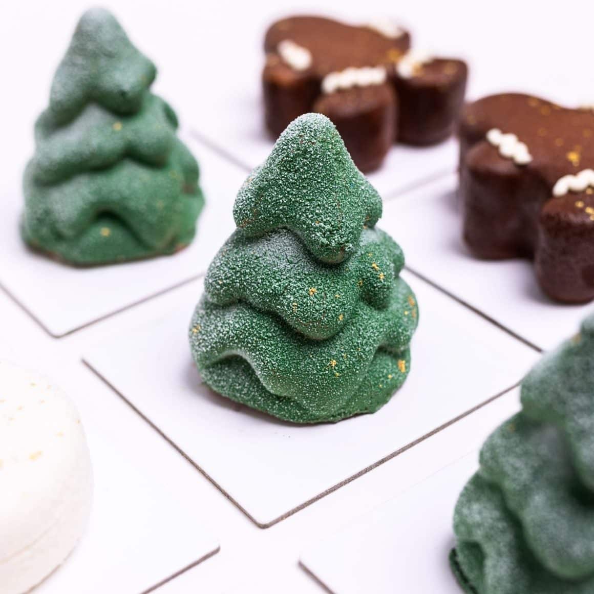 Mousse de ciocolată infuzată cu rozmarin, insert catifelat de portocală, blat de ciocolată și strat crocant de feuilletine. Un brăduț gourmet, cu note de pădure și sărbătoare.