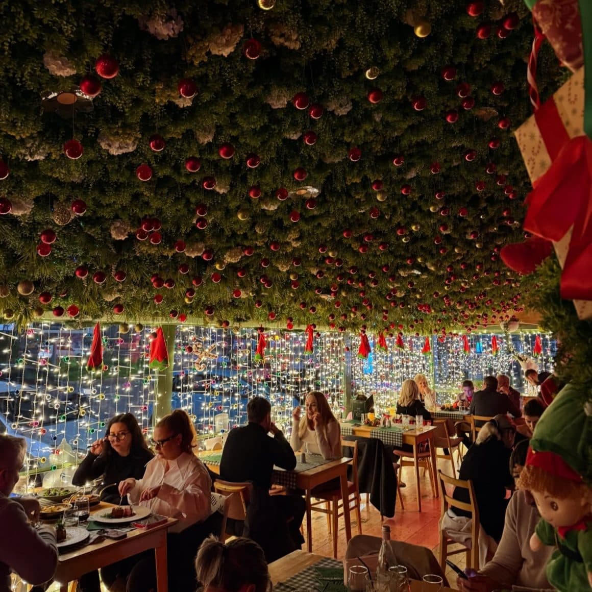 mai multe decorații de crăciun și ghirlande luminoase sunt atârnate pe tavanul restaurantului Bocca Lupo