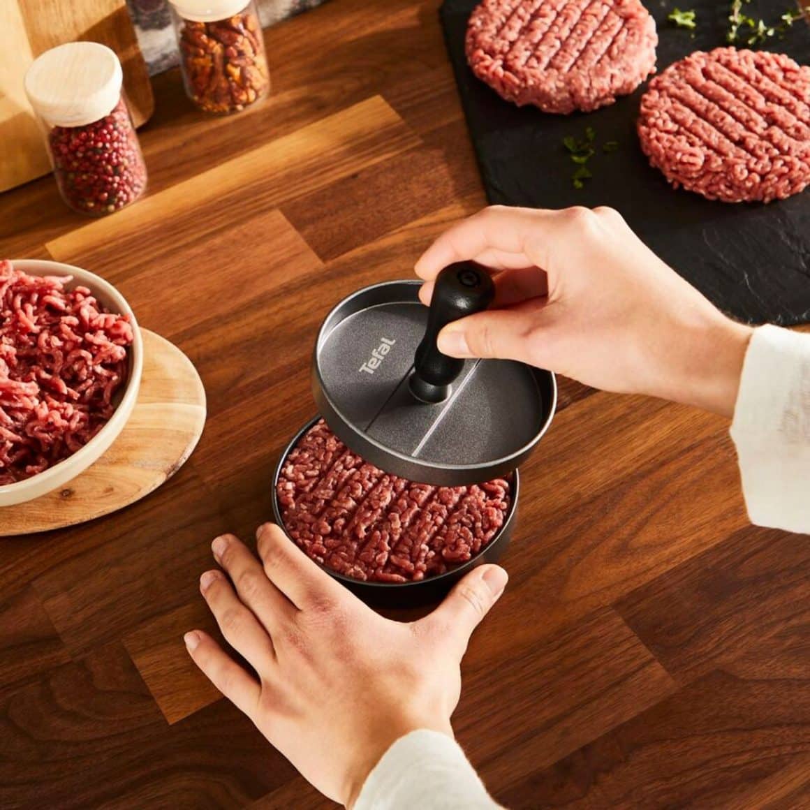 cineva foloseste o presa de burgeri pentru a face chiftele d eburgeri. presa de burgeri tefal. Cadouri de Crăciun pentru foodies