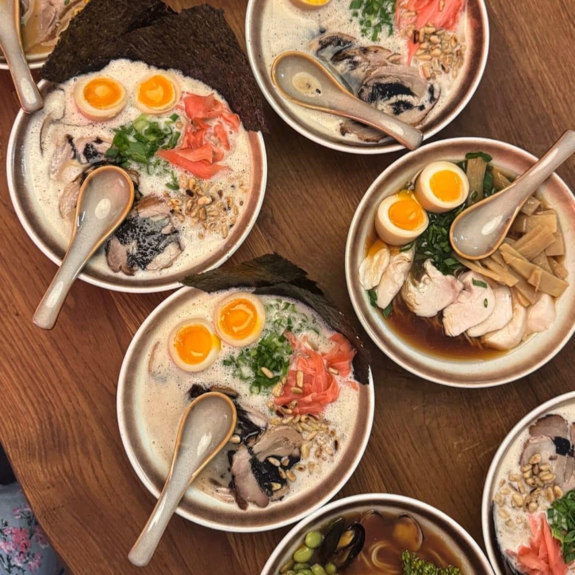 Boluri de ramen japonez servite la restaurantul Nishibo, cu ou marinat, carne fragedă, alge nori și toppinguri autentice, fotografiate de sus.