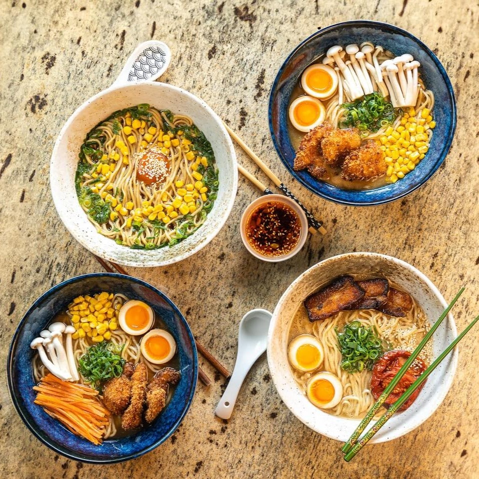 Boluri de ramen în București, servite la Sanki Ramen Bar, cu ou marinat, porumb, ciuperci enoki, carne crocantă și noodles proaspeți, fotografiate de sus.