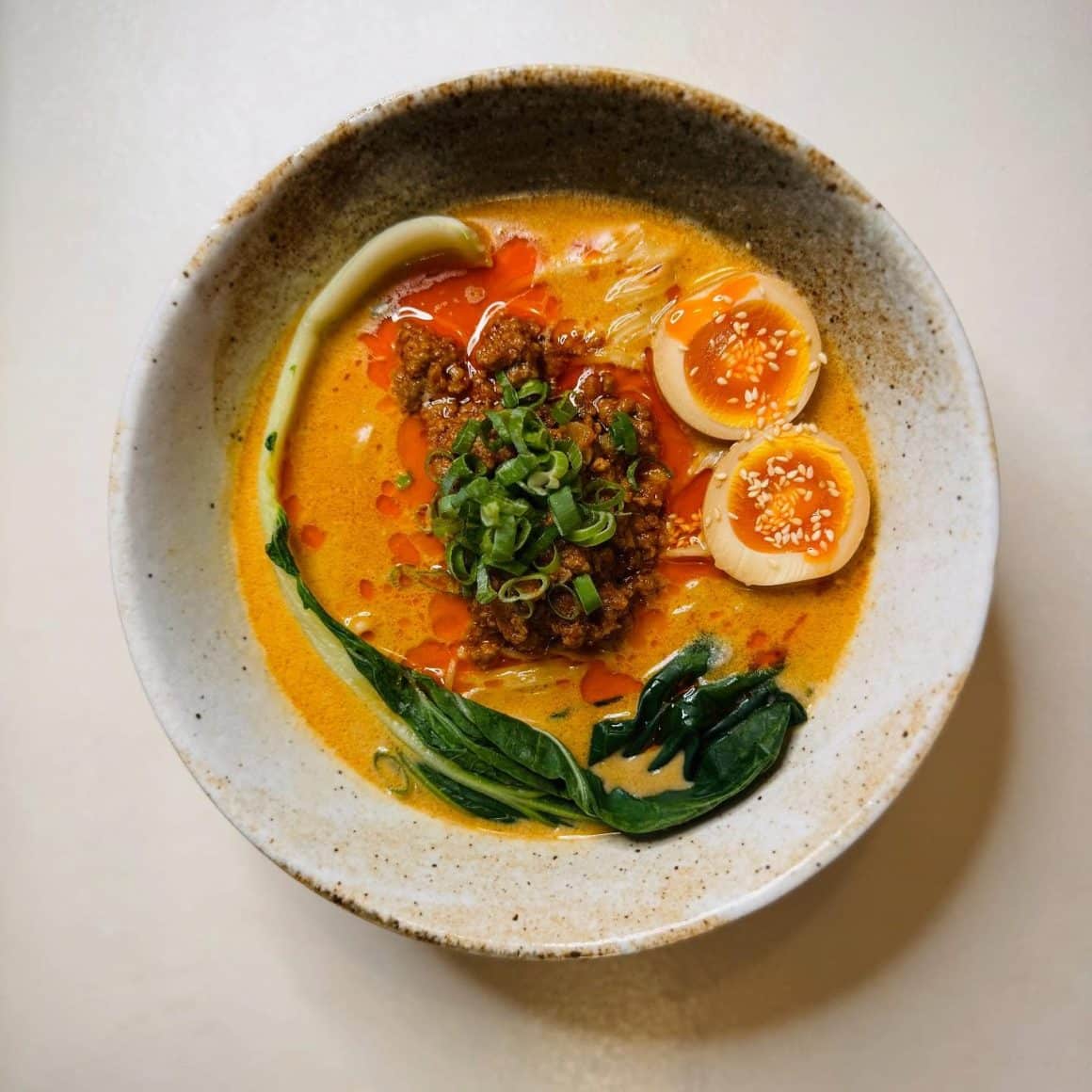 Bol de Tan Tan ramen în București de la Sanki Ramen Bar, cu supă cremoasă, ou marinat, carne condimentată și legume asiatice, servit într-un stil japonez curat.