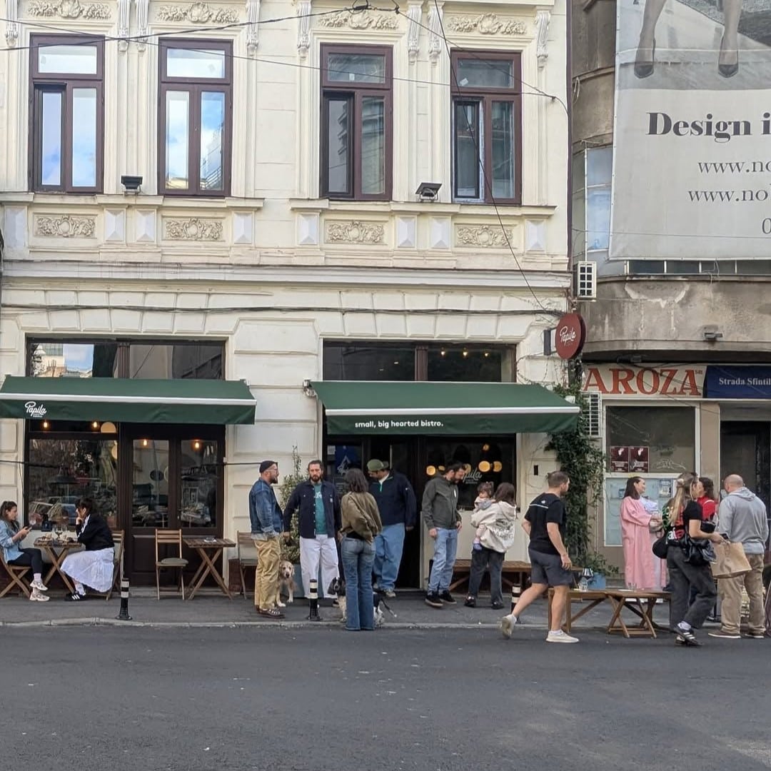 Fațada bistroului Papila din București, cu terasă animată și oameni la mese, un reper pentru ramen în București și bucătărie modernă.