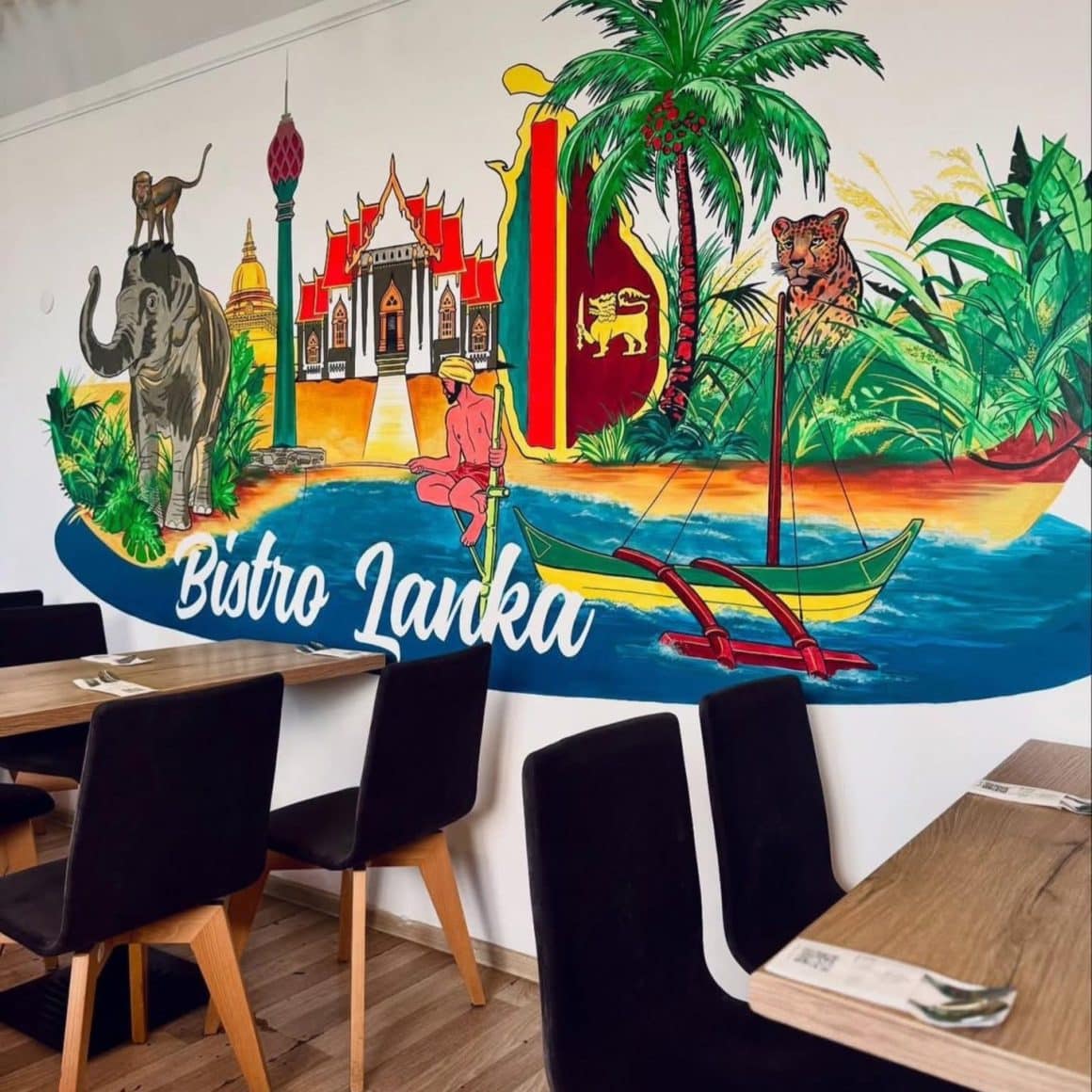 Interiorul restaurantului Bistro Lanka din București, cu mural colorat inspirat din Sri Lanka și decor casual.