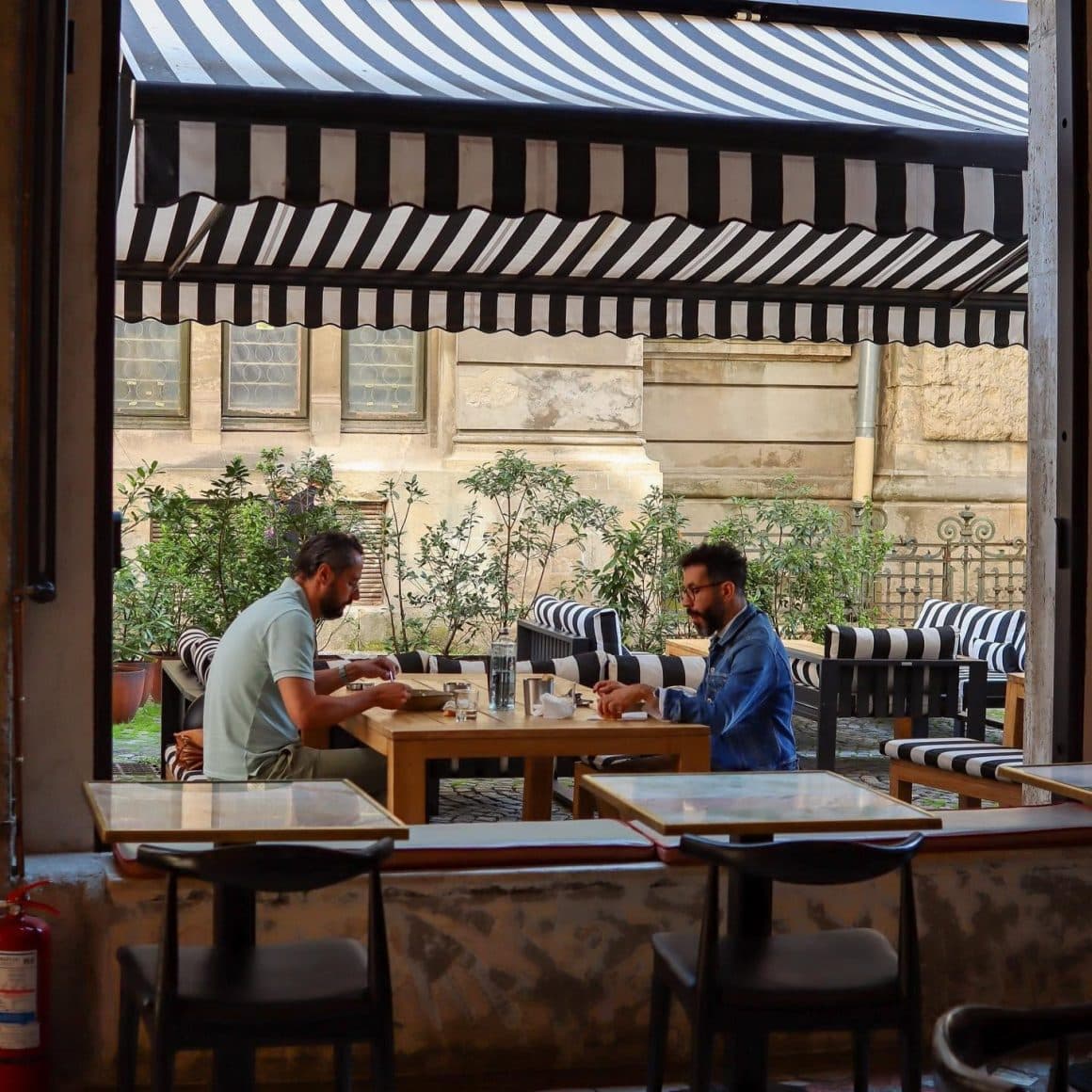 2 barbati iau masa pe terasa restaurantului Le Bab din Centrul vechi. Restaurante Calea Victoriei