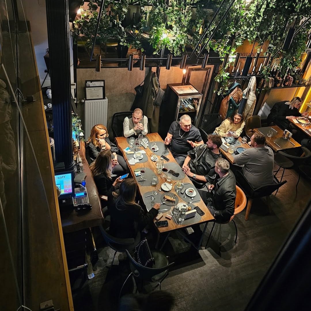 Oameni care iau masa in interiorul modern de la restaurant Noa Resto Club. Restaurante bune pe Calea Victoriei