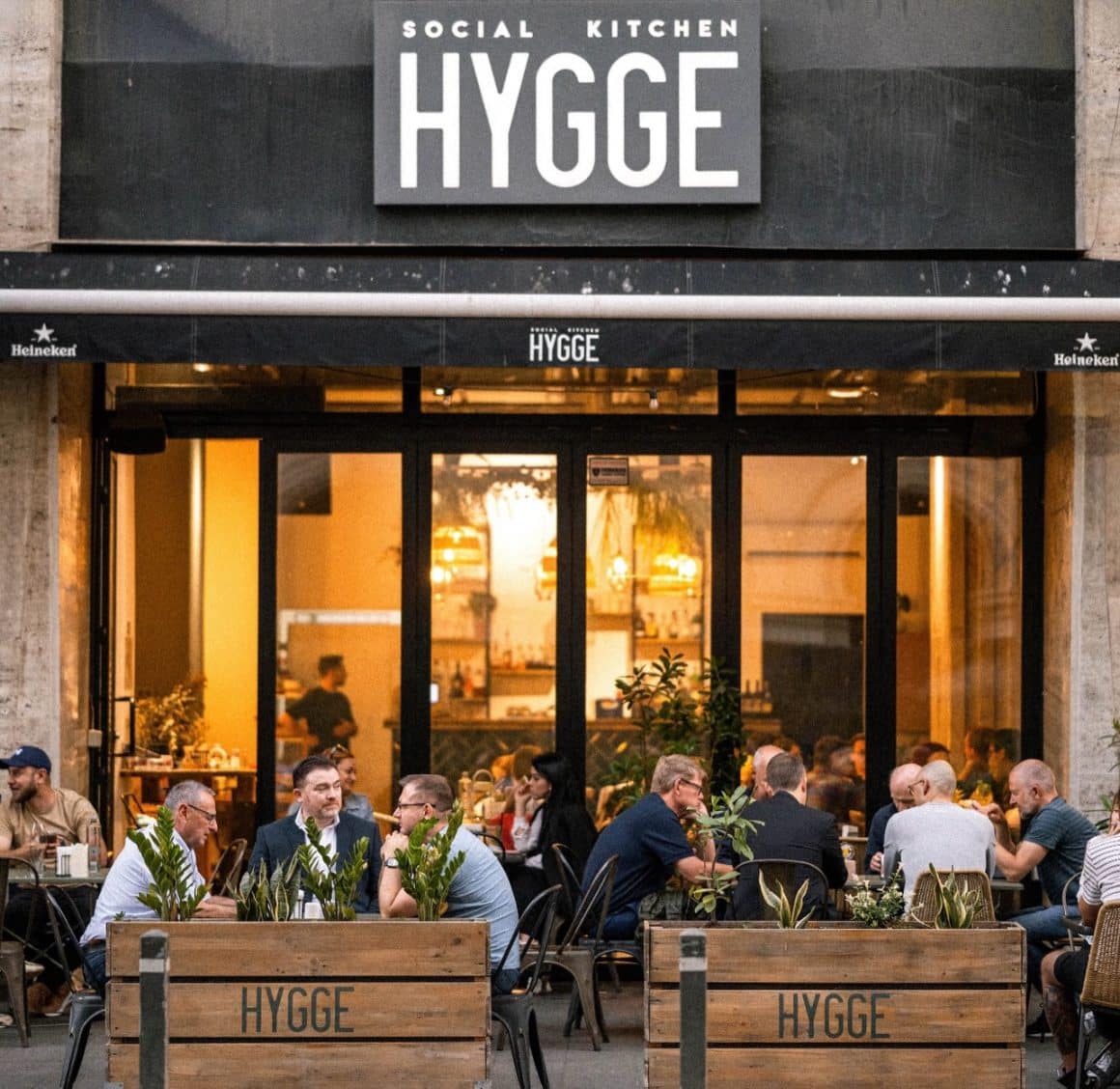 oameni care iau masa pe terasă la Hygge Social Kitchen. Restaurante Calea Victoriei
