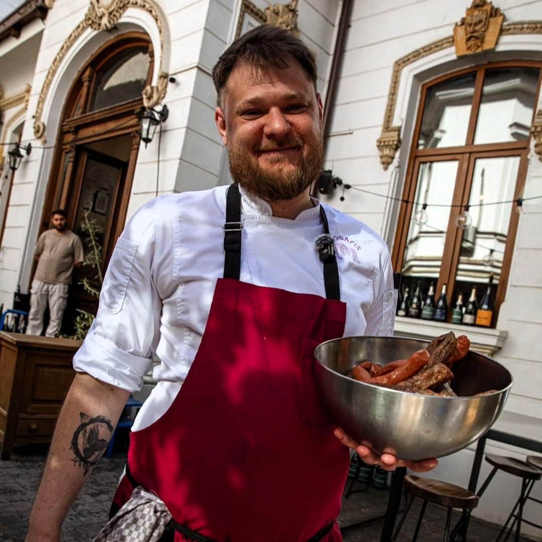Alex Wolff (Burcã), chef Mosafir, serveste un castron de cârnați la grătar pe terasa