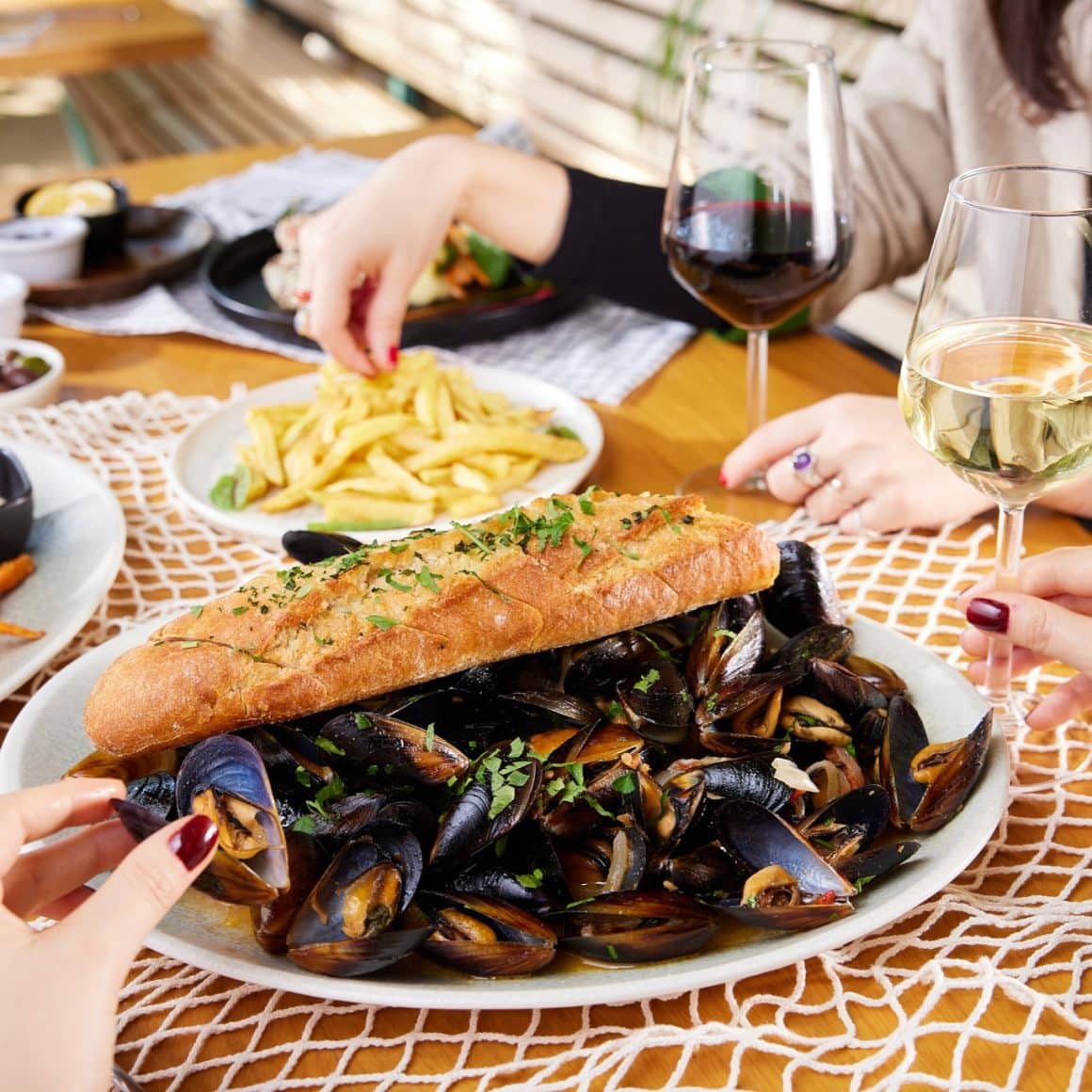 platou mare cu midii și pâine cu usturoi, servit cu vin alb la restaurant pescăresc Pescăruș