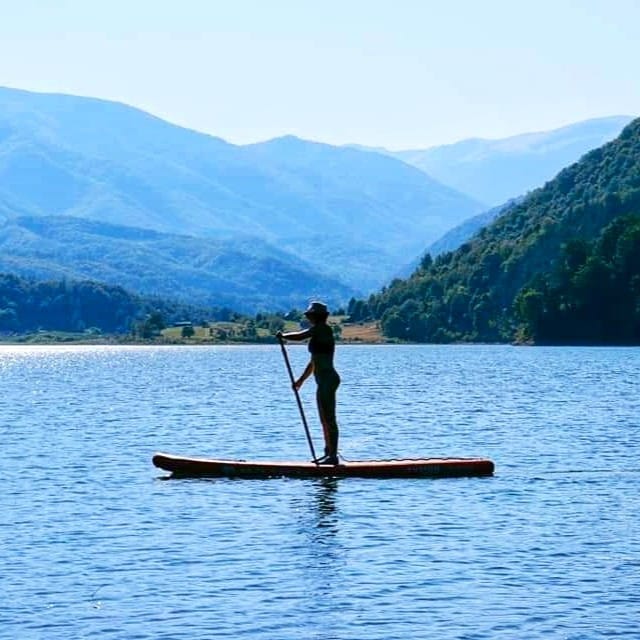 barbat in picioare pe placa, pe lac