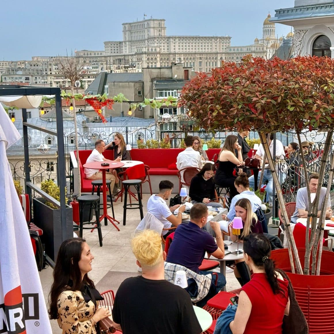 Rooftop Bars București. Bartini. Terasa de tip skybar plina de oameni care iau masa si se relaxeaza