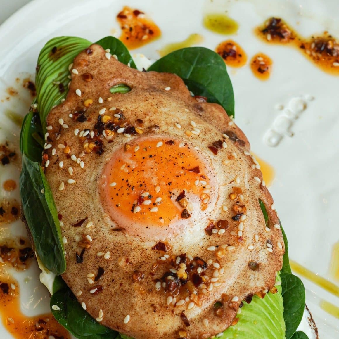 Spicy Oil Egg este combinația perfectă între un toast clasic delicios cu pâine cu maia, cremă de brânză, avocado, baby spanac și un ou prăjit perfect și un twist de arome asiatice date de toppingurile noastre de inspirație asiatică.