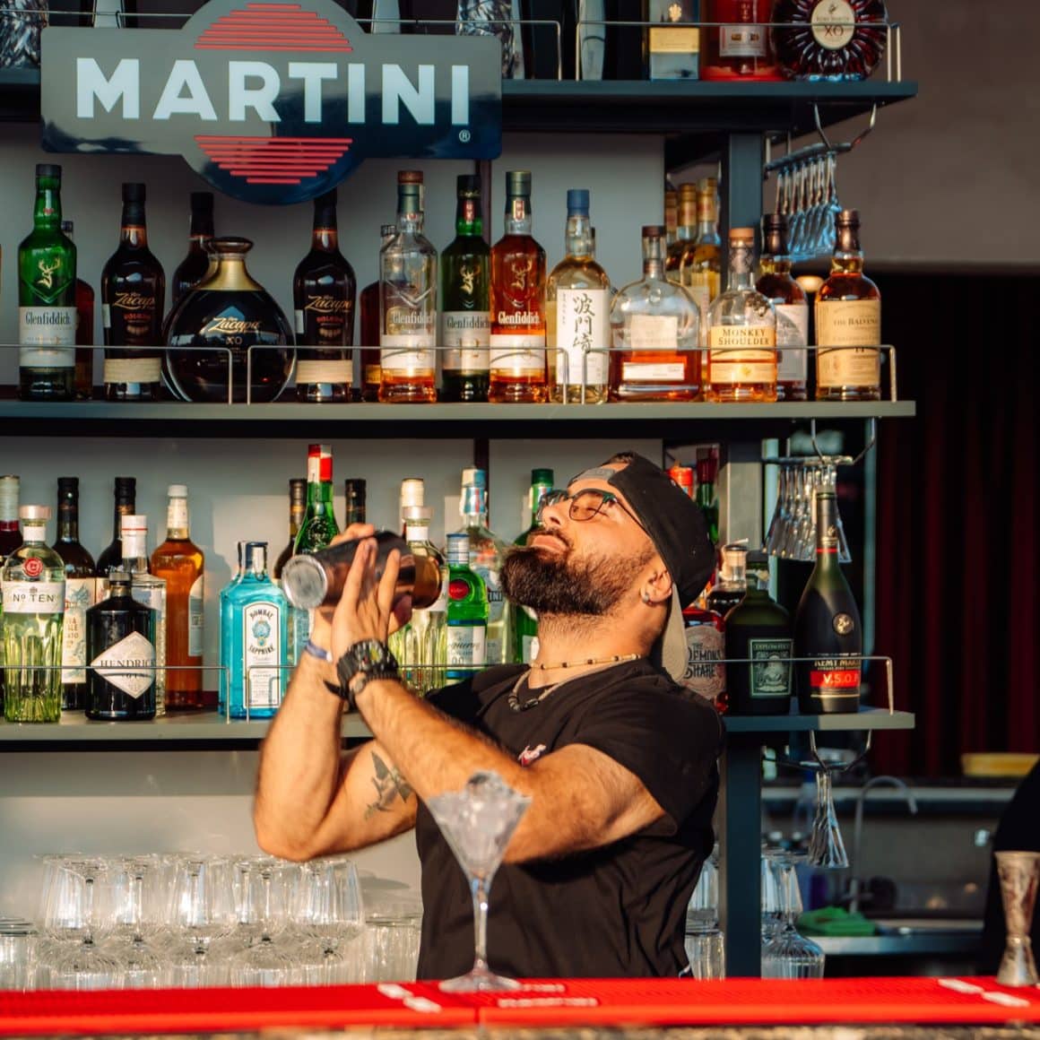 Barman mixeaza cocktailuri in barul de la Bartini Rooftop Bar din București