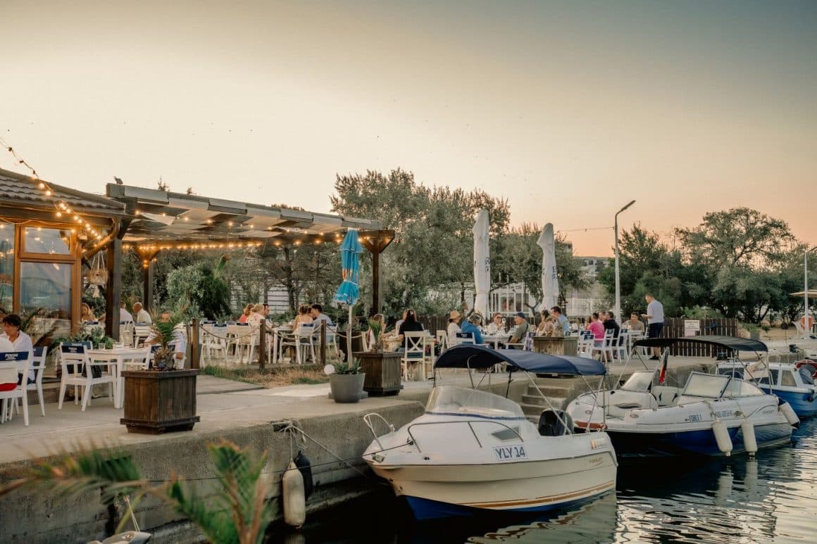mai multi oameni iau masa in marina de pe aleea belona din eforie nord, la cherhana Sailors, una din cele mai bune cherhanale din eforie