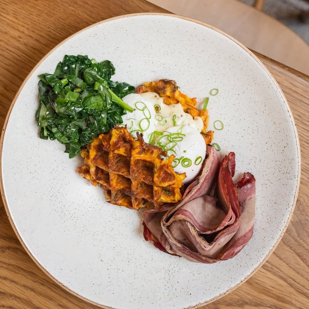 Waffles and then some: waffles de legume, ouă poșate, brisket de vită făcut în casă, kale tras la foc în unt brun și sos tartar fresh. Brunch București la DeSoi