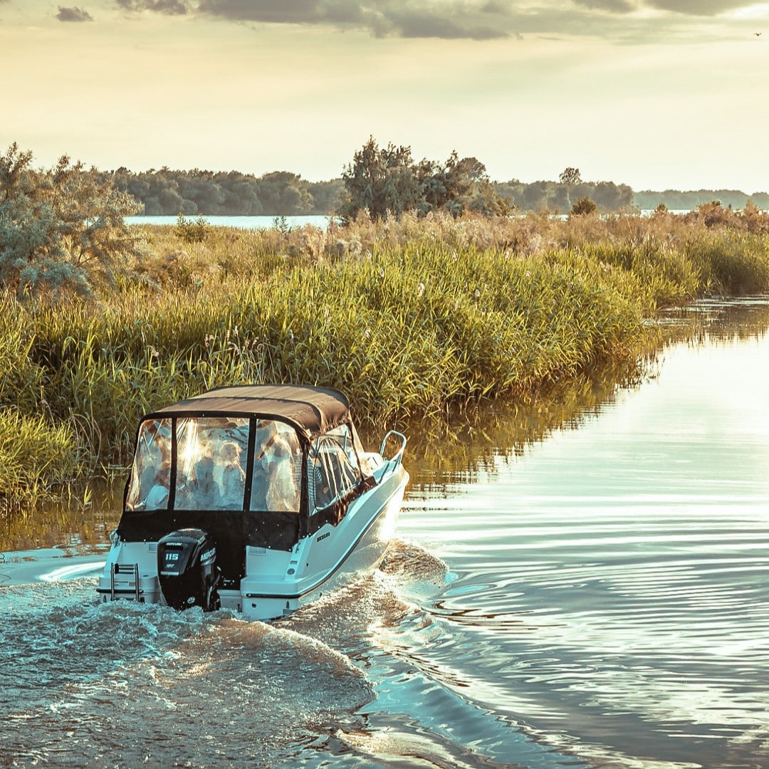 o barca cu motor se plimbă pe canalele Dunării