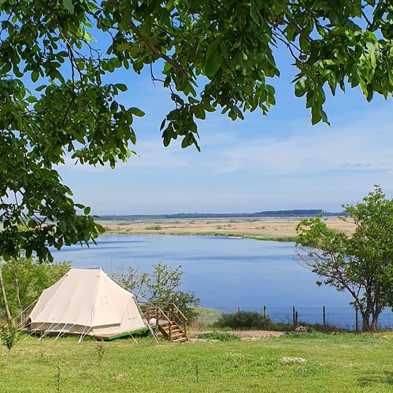 cort asezat pe iarba, iar in fundal se vede Dunărea. Cele mai frumoase campinguri din România