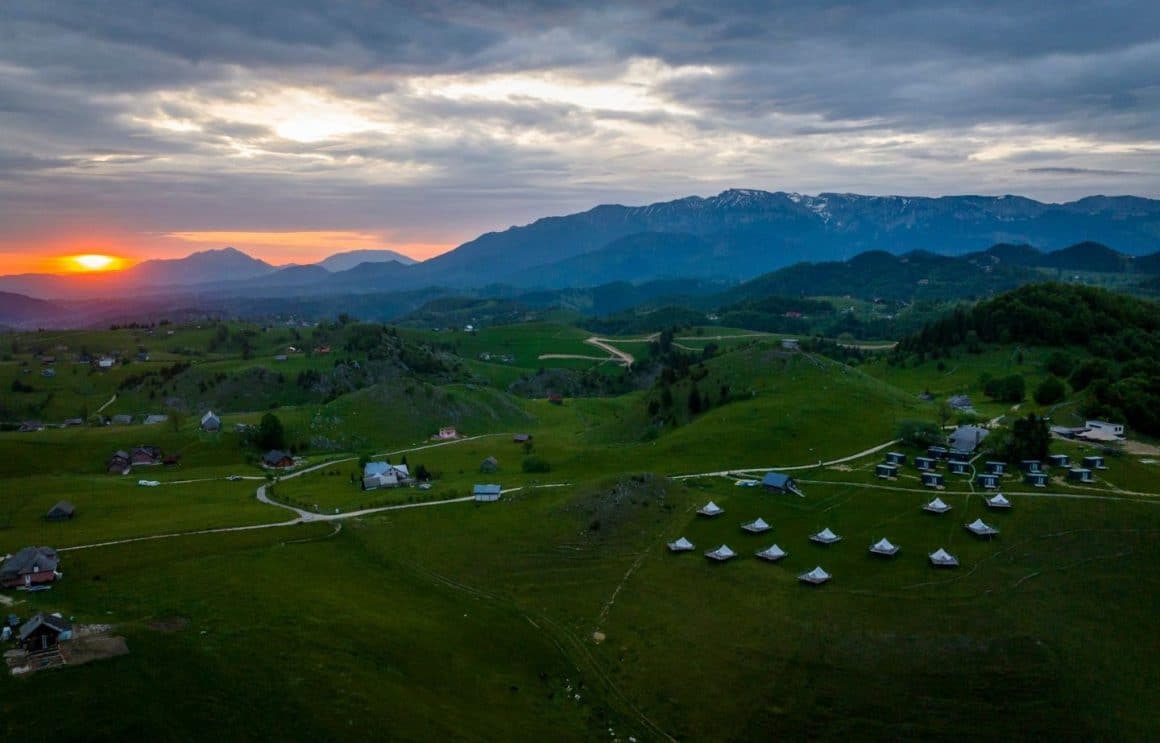 mai multe corturi de glamping răsfirate pe un deal inverzit. Ursa Mică. 