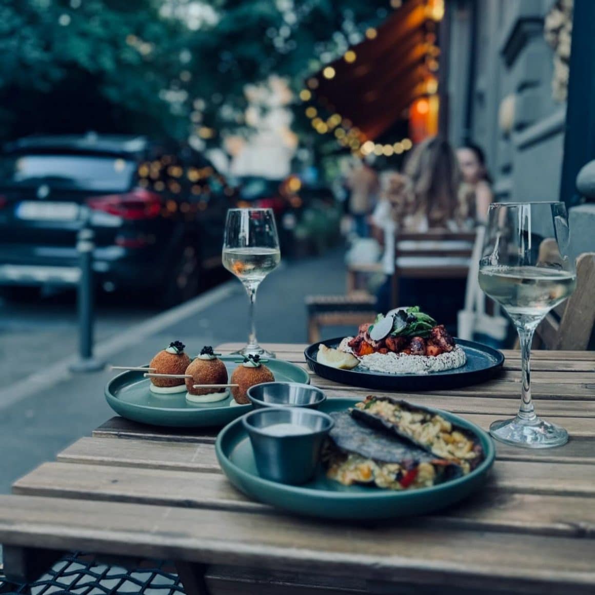 farfurii cu croquetas, tacos și vin alb pe terasa la Salon Golescu.
