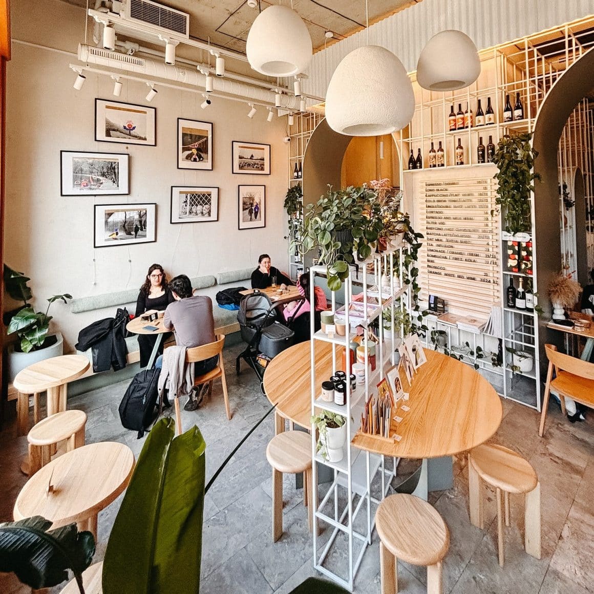 Interiorul de la Sip Coffee & Wine Bar are mese rotunde din lemn, iluminat cald și un decor modern, ceea ce îl face potrivit pentru lucrat câteva ore.