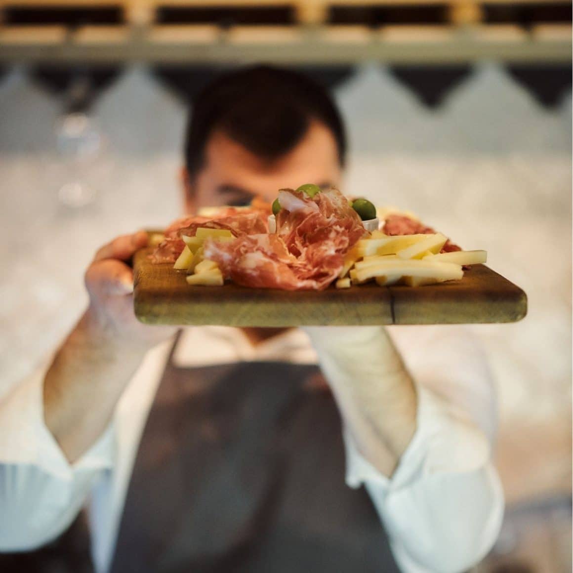 Tapas în București la VINO Bubbles & Tapas, platouri cu mezeluri, brânzeturi și măsline servite pe lemn.