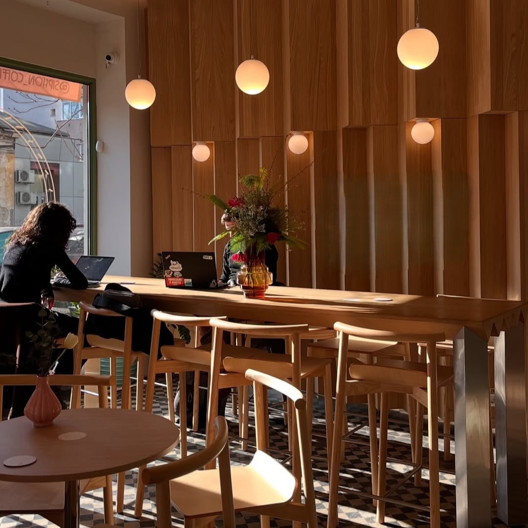 Siphon Coffee are un interior modern, cu mult lemn și lumină caldă, iar mesele sunt potrivite pentru lucru la laptop sau întâlniri rapide.