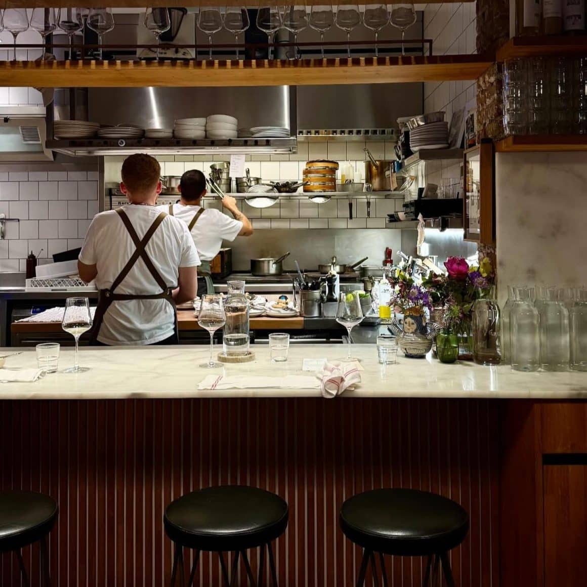 Bucătărie deschisă la Berbena, unde mâncarea e pregătită la vedere într-un decor cozy și familiar. Restaurante din Barcelona