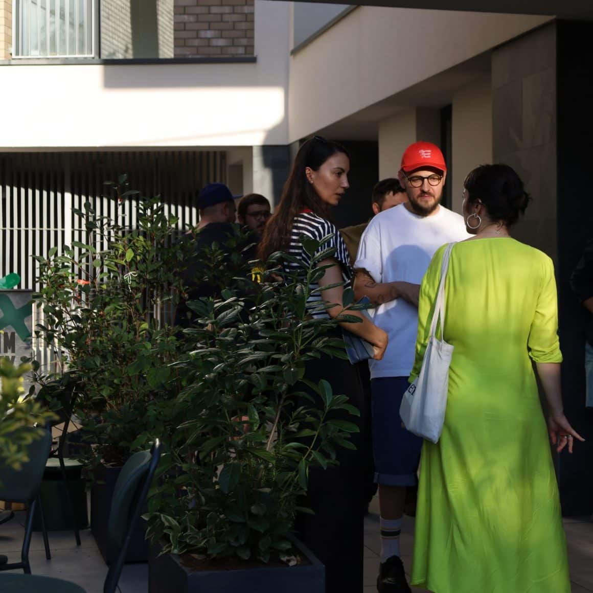 Mai multi tineri stau de vorba pe terasa unei cafenele