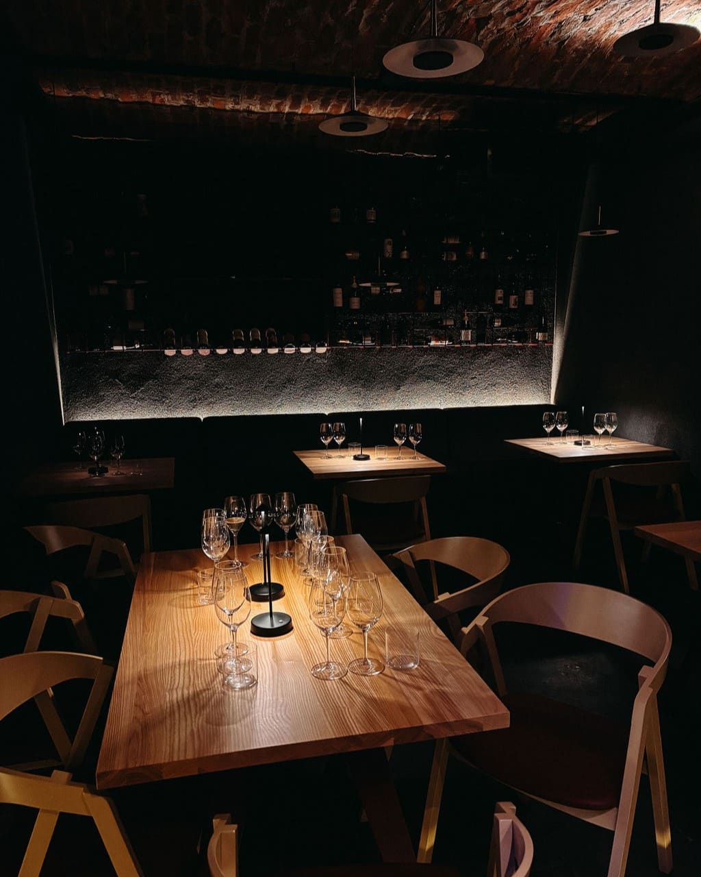 mese de lemn, moderne, cu pahare de vin, in lumina difuza si intima la Sip Coffee & Wine Bar