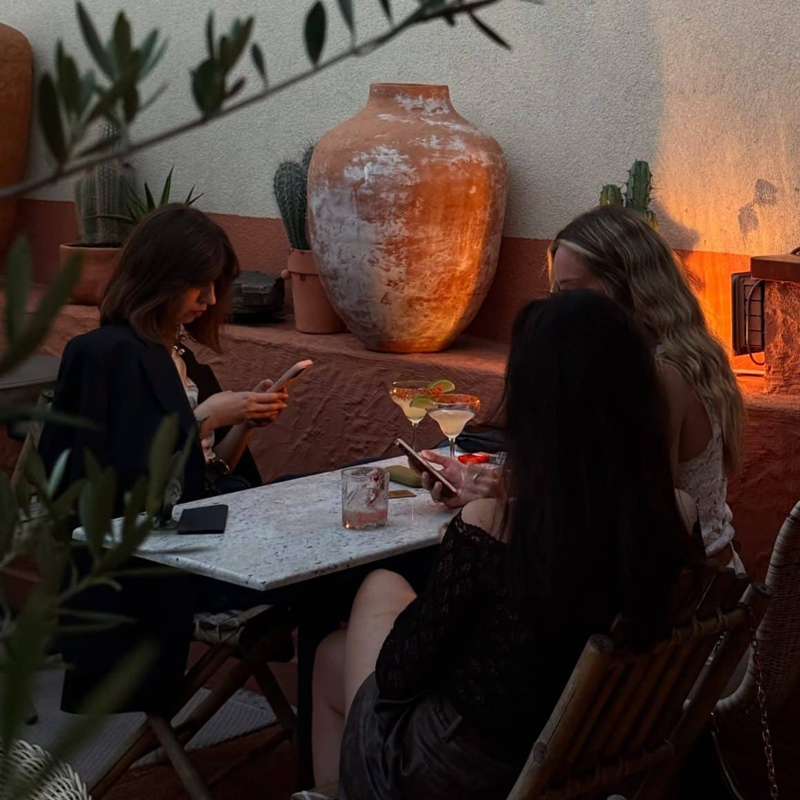 3 femei tinere stau la masa pe tersa la Condesa București, unul din cele mai bune locuri cu tapas în București